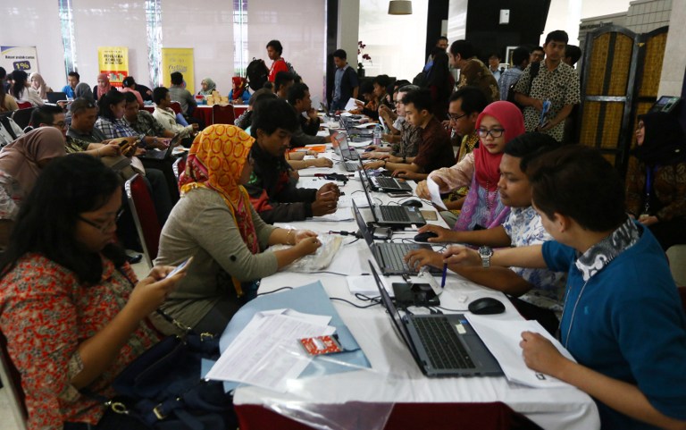 In this photograph taken on September 30, 2016, Indonesians report their tax figures on the last day of the tax amnesty first round program in Jakarta.
Indonesia has hailed a tax amnesty as a major success after it raised more than 7 billion USD in its first few months, but criticism is mounting that the controversial scheme lets the super-rich off the hook. / AFP PHOTO / STR / TO GO WITH Indonesia-taxation-politics-economy,FOCUS by Sam Reeves and Kiki Siregar
