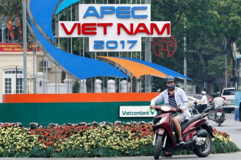 A motorbike waits in front of a sign promoting APEC Summit in Hanoi, Vietnam May 17, 2017. REUTERS/Kham