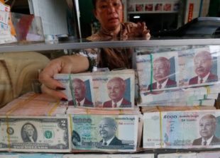 business_a_vendor_places_a_stack_of_cambodian_riel_in_a_counter_at_a_currency_exchange_store_yesterday_in_phnom_penh_07_06_2017_heng_chivoan