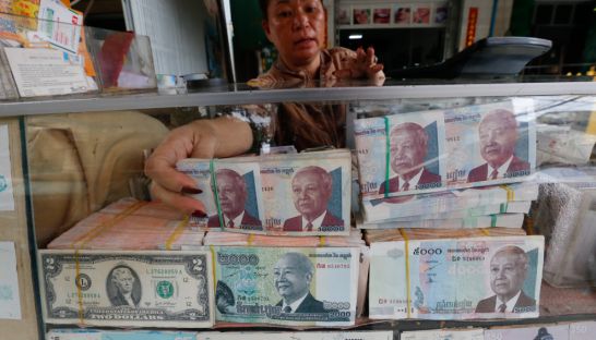 business_a_vendor_places_a_stack_of_cambodian_riel_in_a_counter_at_a_currency_exchange_store_yesterday_in_phnom_penh_07_06_2017_heng_chivoan