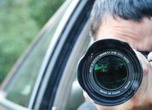 a-representative-image-of-a-private-investigator-photographing-his-subject-from-a-car-supplied