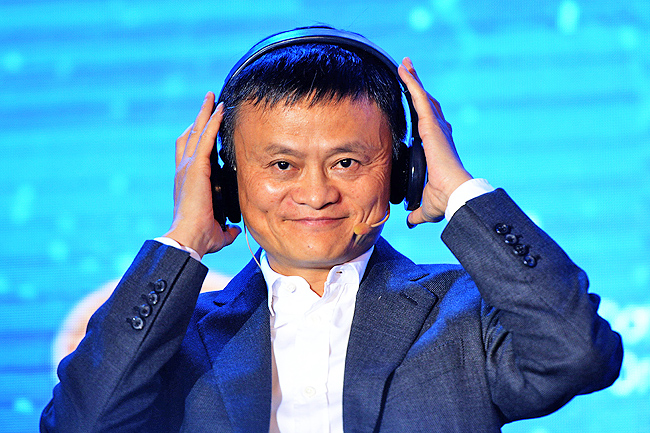 Jack Ma, Chinese billionaire and Chairman of Alibaba puts on headphones as he attends a forum on E-payment, the Vietnam E-Payment Forum, in Hanoi on November 6, 2017. / AFP PHOTO / HOANG DINH NAM