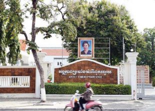 business_a-motorbike-passes-in-front-of-the-anti-corruption-unit-headquarters-in-phnom-penh_pha-lina