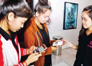 customers-purchase-movie-tickets-using-the-pi-pay-app-on-their-smartphones-in-phnom-penh-heng-chivoan