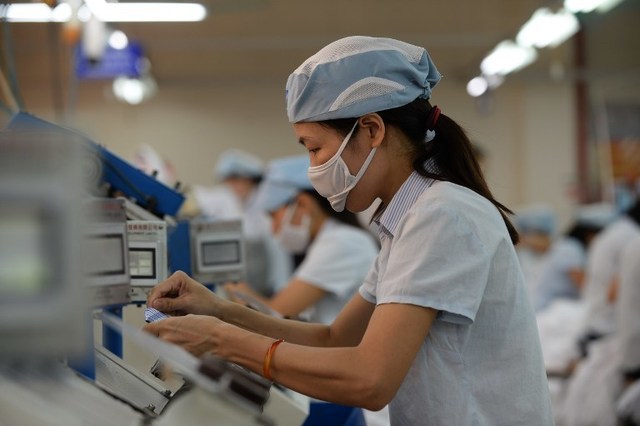 TO GO WITH STORY: Vietnam-trade-commerce-TPP, FOCUS by Catherine Barton
This picture taken on October 20, 2015 shows female workers  on a production line at the Garment 10 Company in the outskirts of Hanoi.  After organising communist Vietnam's first peaceful mass strike at a shoe factory, labour activist Do Thi Minh Hanh was arrested, beaten bloody by police,  and jailed for four years. Authoritarian Vietnam does not allow the millions of workers in its export-orientated factories,  which are driving impressive growth of 6.68 percent in 2015,  to form independent trade union.  AFP PHOTO / HOANG DINH NAM / AFP / HOANG DINH NAM