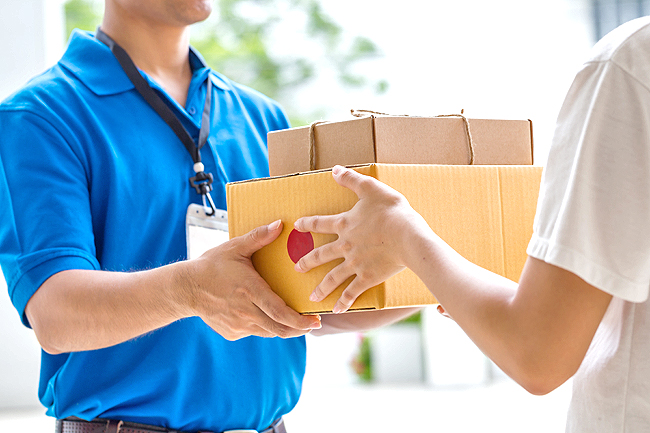 Woman hand accepting a delivery of boxes from deliveryman