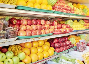 Various colorful ripe fresh fruits on shelves in grocery store