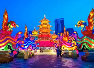 TOPSHOT - People visit a festive installation of illuminated pagodas and mythical animals erected outside a shopping mall to celebrate the upcoming Lunar New Year in Bangkok on January 29, 2021. (Photo by Mladen ANTONOV / AFP)