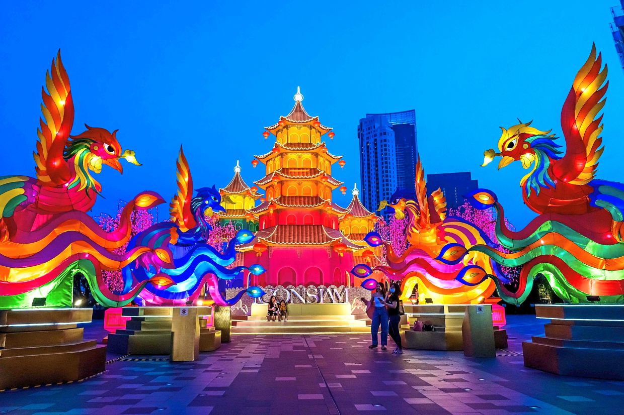 TOPSHOT - People visit a festive installation of illuminated pagodas and mythical animals erected outside a shopping mall to celebrate the upcoming Lunar New Year in Bangkok on January 29, 2021. (Photo by Mladen ANTONOV / AFP)