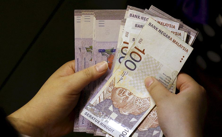 A customer counts her ringgit notes outside a money changer at the central business district in Singapore in this August 25, 2015 file photo.  Malaysia's ringgit jumped more than 5 percent to a five-week high on October 7, 2015 on stop-loss dollar selling and higher local stocks.  The ringgit, the worst performing Asian currency so far this year, surged as much as 5.2 percent to 4.1600 per dollar, its strongest since Sept 1.     REUTERS/Edgar Su/Files