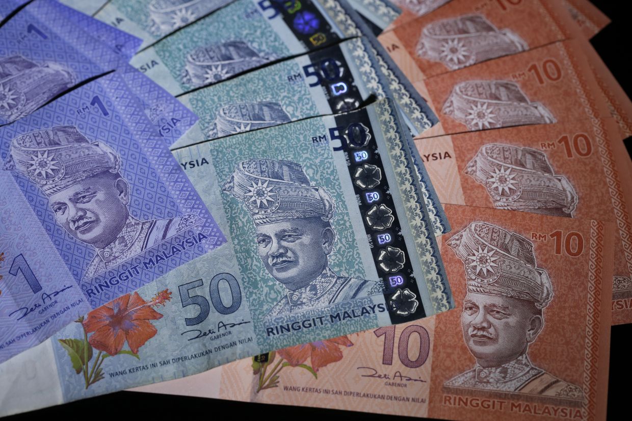 Malaysian ringgit banknotes of various denominations are arranged for a photograph in Tokyo, Japan, on Friday, Aug. 14, 2015. Malaysia's ringgit plunged the most since 1998 on concern the nation is running out of ammunition to defend its currency amid a political scandal, a yuan devaluation and slumping oil prices. Stocks and bonds tumbled. Photographer: Kiyoshi Ota/Bloomberg