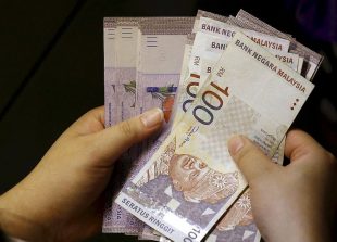 A customer counts her ringgit notes outside a money changer at the central business district in Singapore in this August 25, 2015 file photo.  Malaysia's ringgit jumped more than 5 percent to a five-week high on October 7, 2015 on stop-loss dollar selling and higher local stocks.  The ringgit, the worst performing Asian currency so far this year, surged as much as 5.2 percent to 4.1600 per dollar, its strongest since Sept 1.     REUTERS/Edgar Su/Files