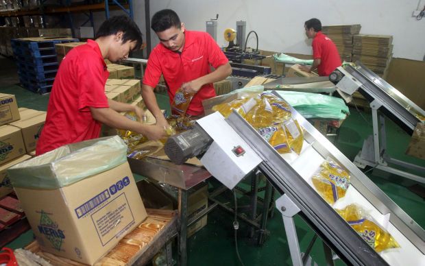 Workers  packing cooking oil at a factory in Klang.
AZHAR MAHFOF/The Star