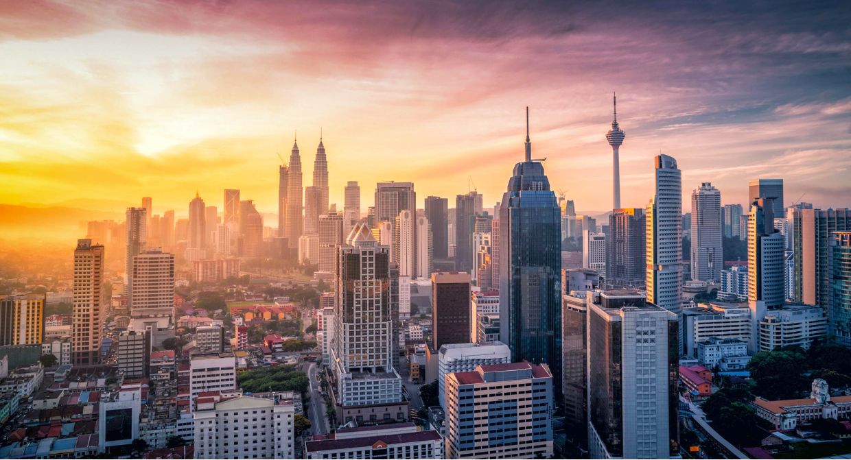 Cityscape of Kuala lumpur city skyline with swimming pool on the roof top of hotel at sunrise in Malaysia.